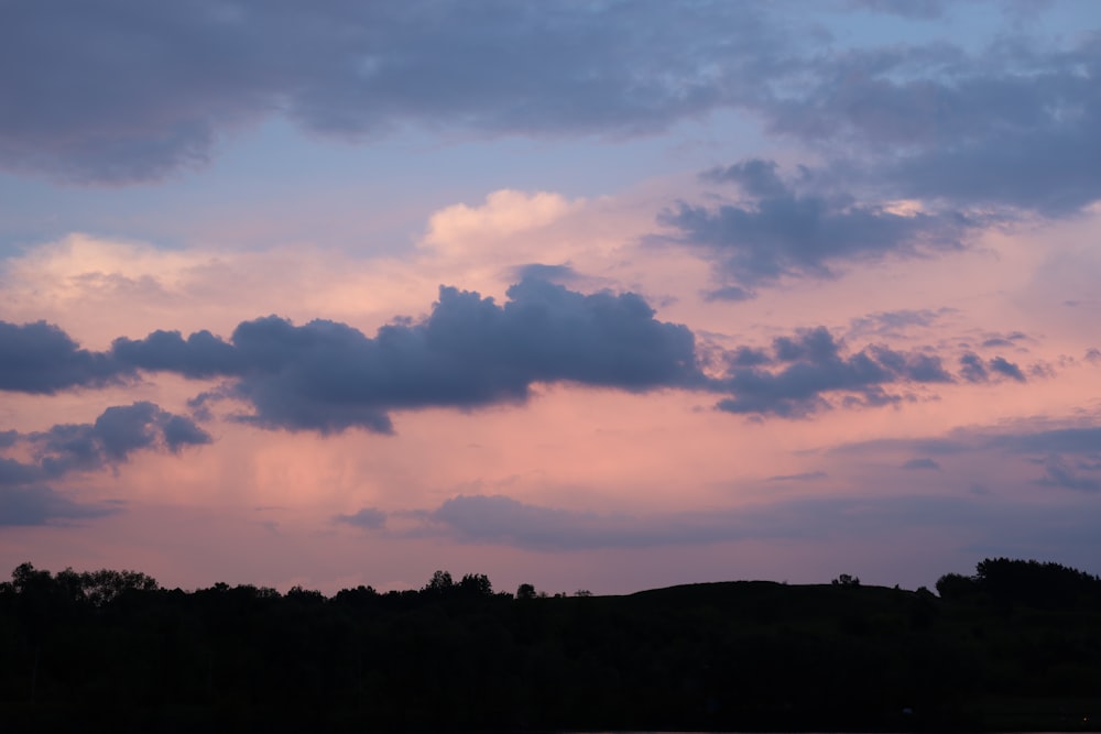 a plane is flying in the sky at sunset