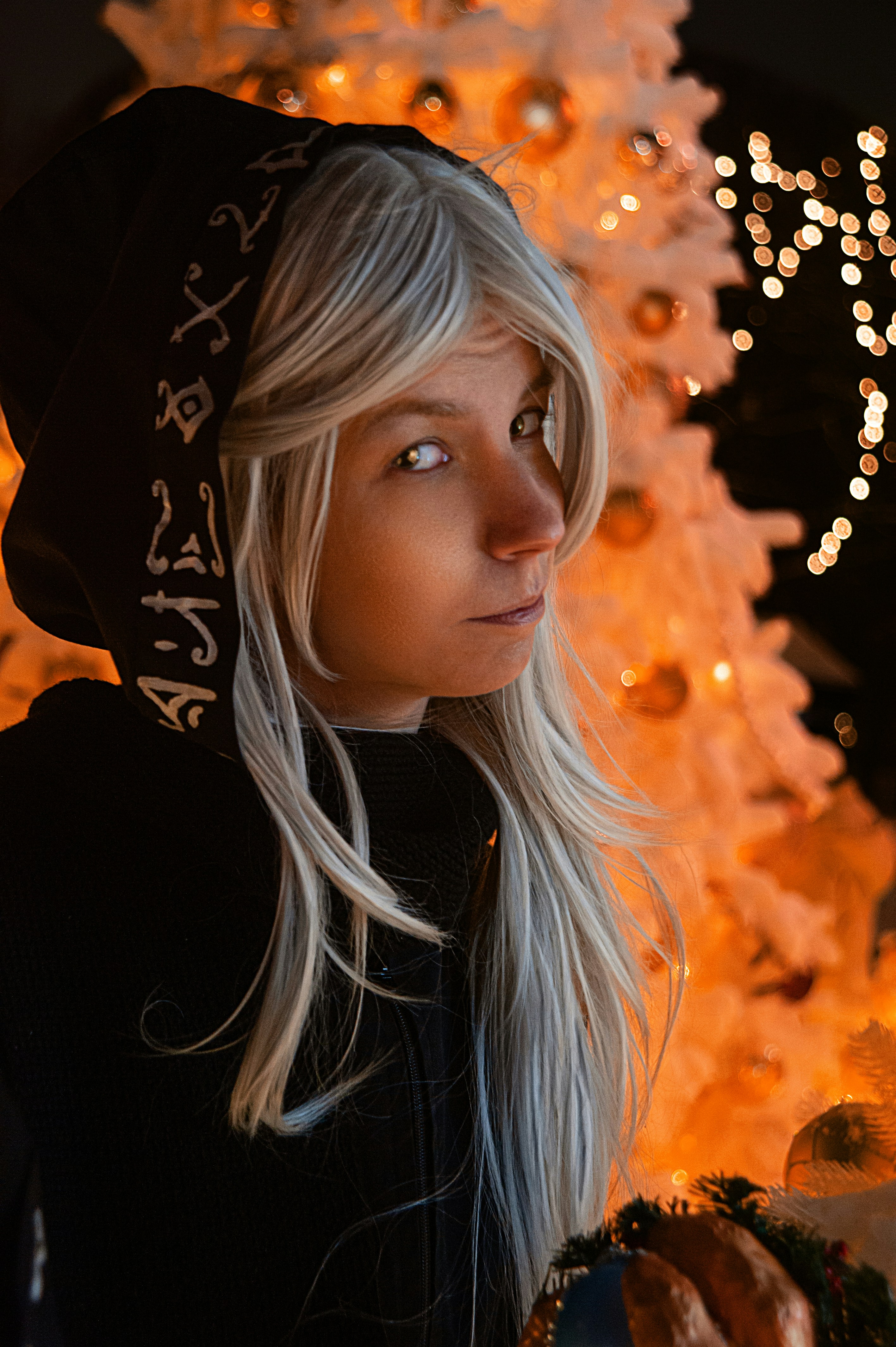 a woman standing in front of a christmas tree