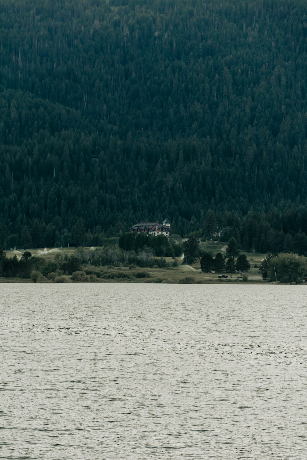 a large body of water with a house in the background