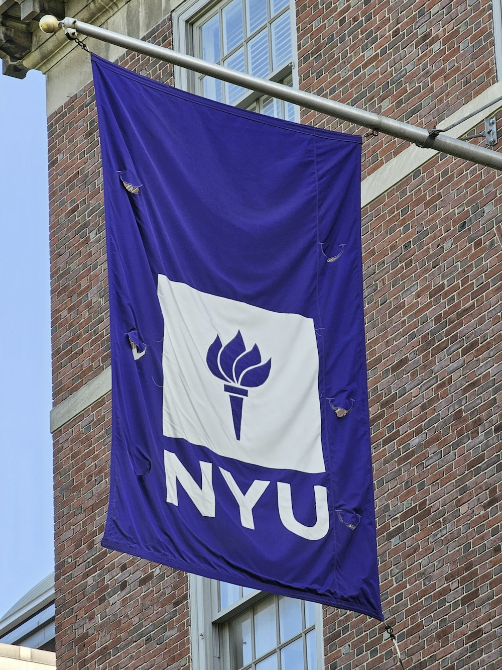 a blue flag hanging from the side of a building