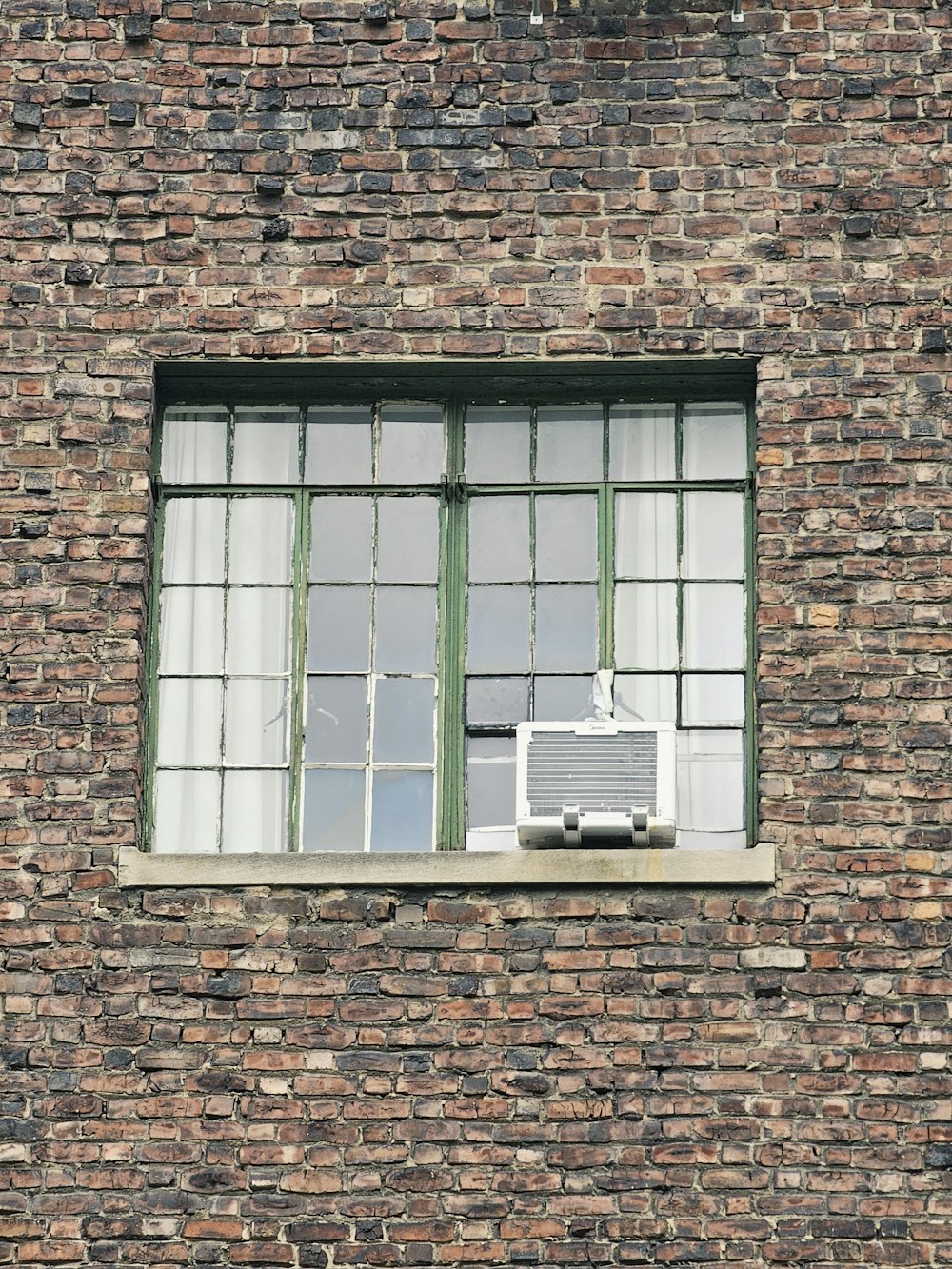 a brick building with a window and air conditioner
