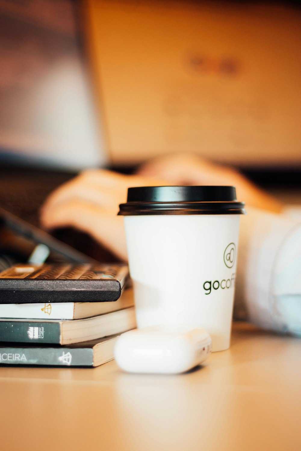 a cup of coffee sitting next to a stack of books