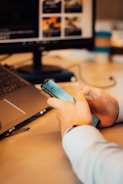 a person sitting at a desk using a cell phone