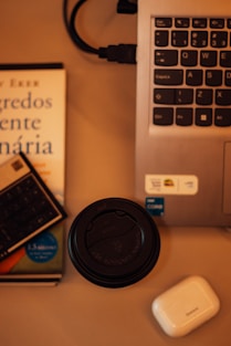 a laptop computer sitting on top of a desk next to a book