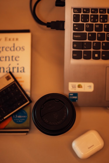 a laptop computer sitting on top of a desk next to a book