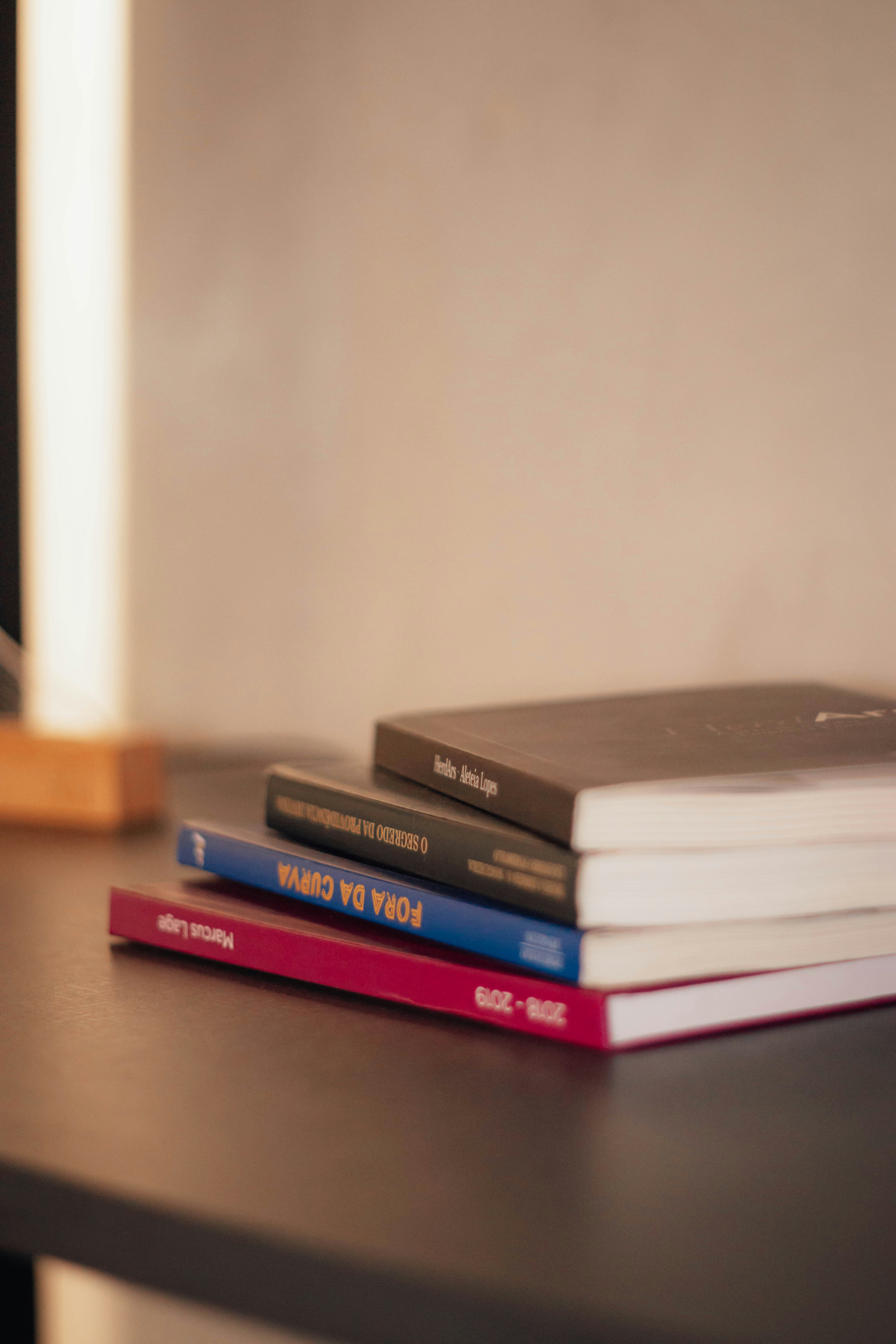 a stack of books sitting on top of a wooden table
