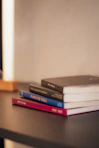 a stack of books sitting on top of a wooden table