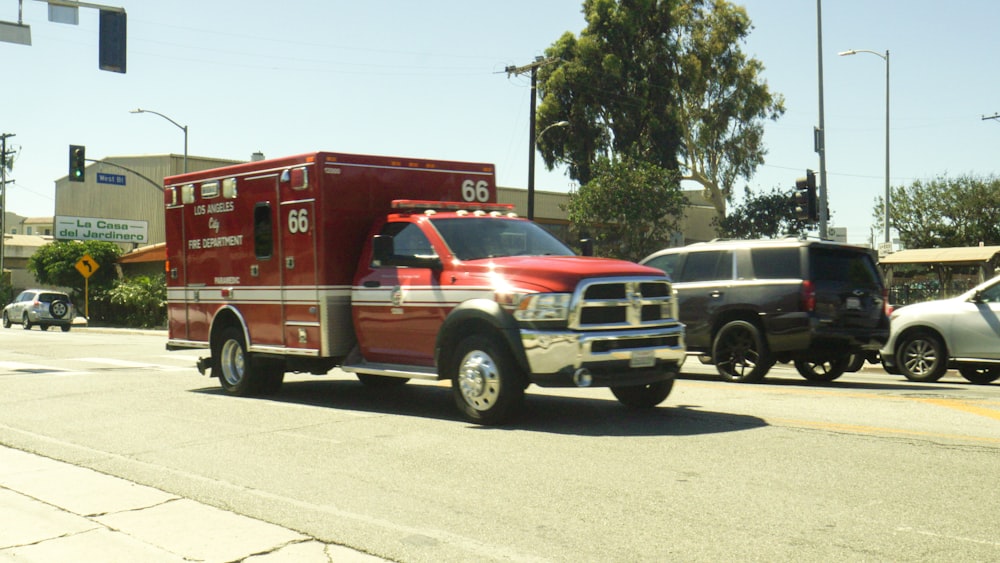 a red emergency truck driving down a street