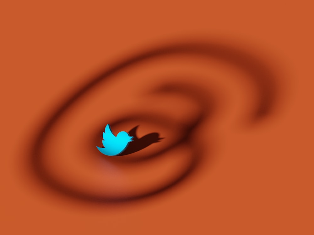 a blue twitter bird flying through the air