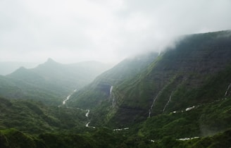 a view of a valley with a waterfall in the middle of it