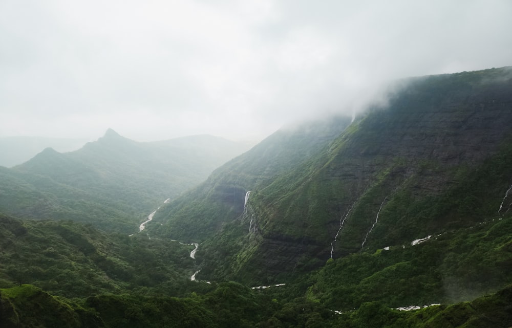 a view of a valley with a waterfall in the middle of it