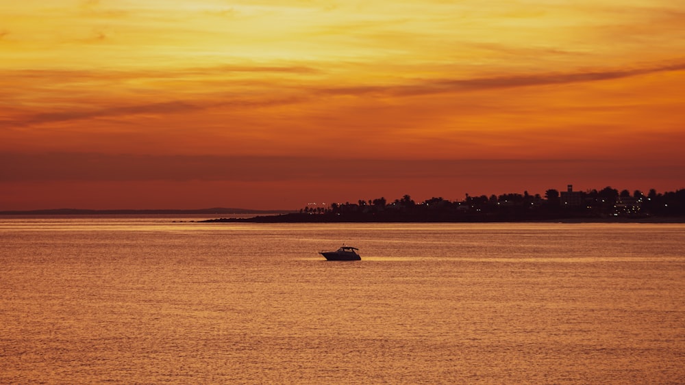 a boat is out on the water at sunset