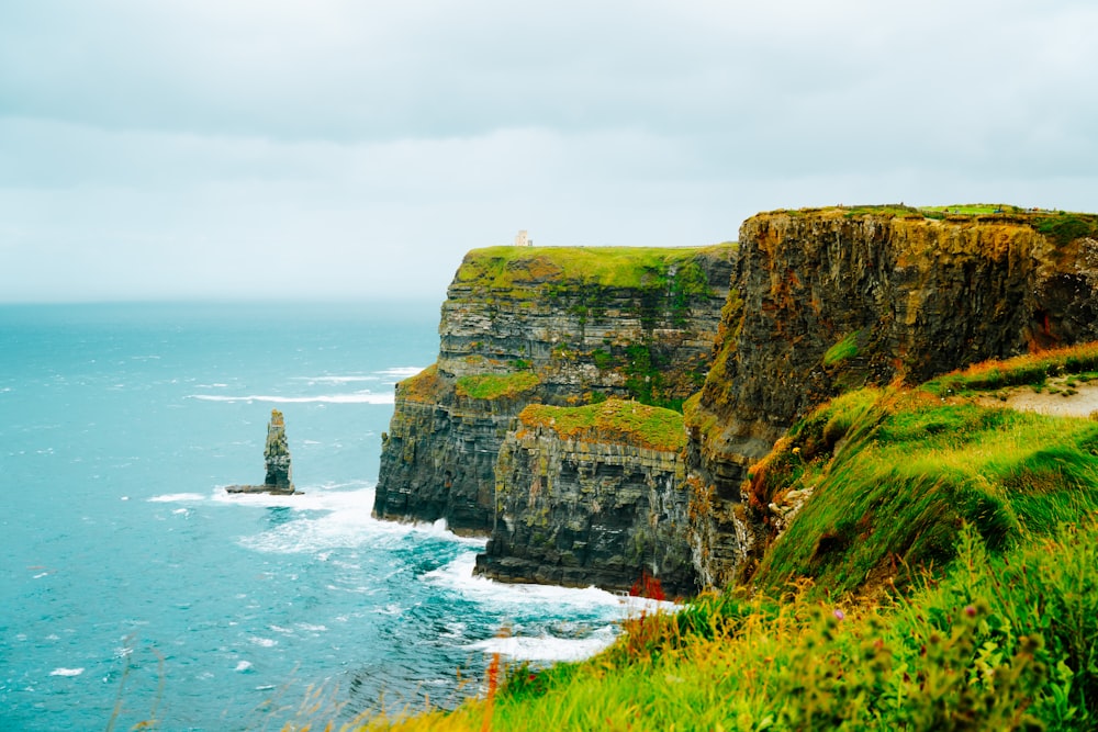 a cliff overlooking the ocean on a cloudy day