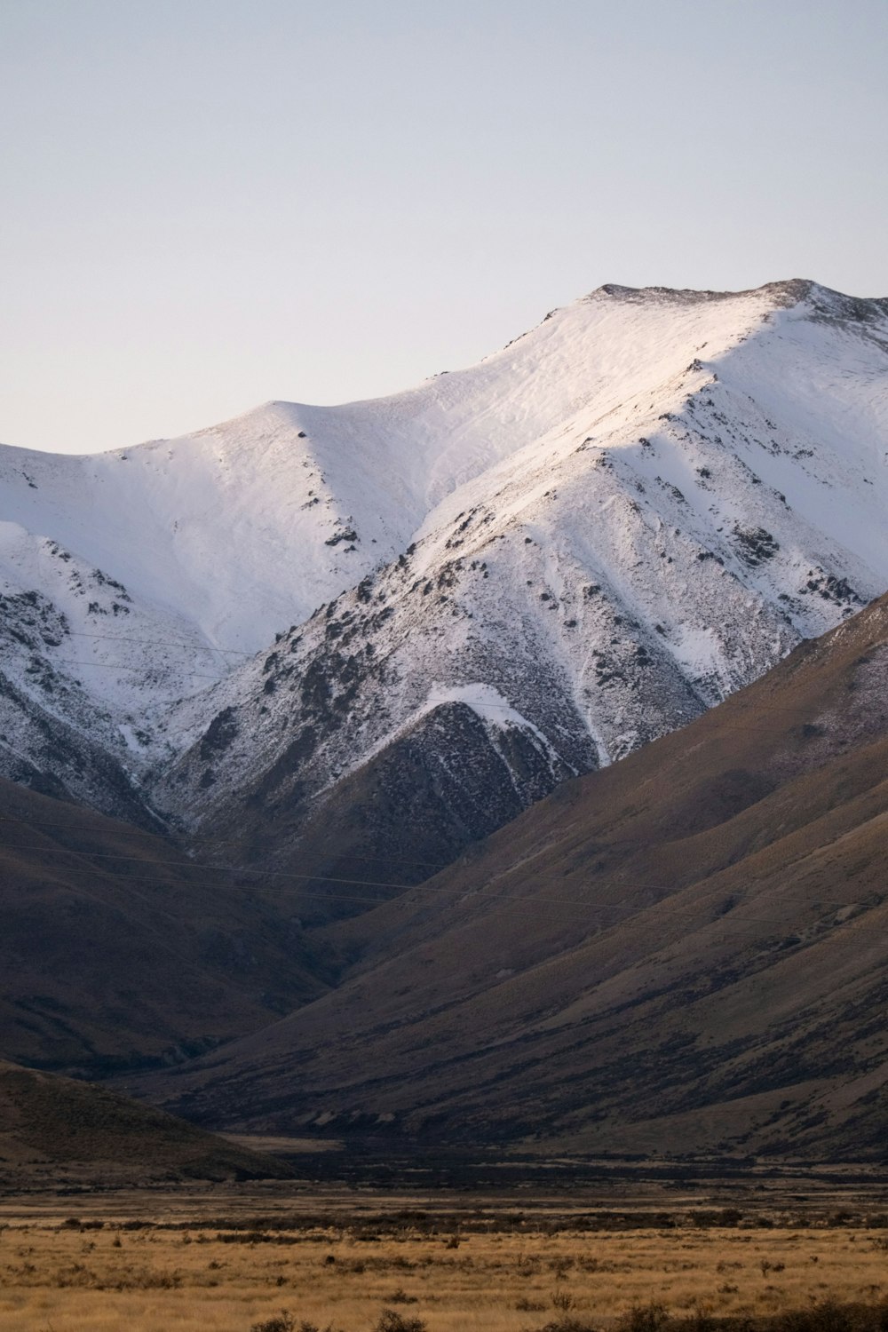 a snow covered mountain range in the middle of the desert