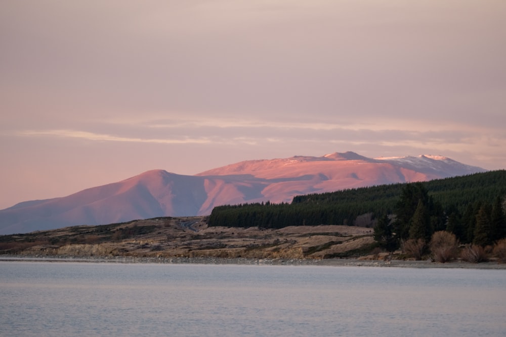 a large body of water with a mountain in the background