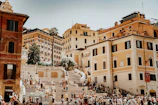 A bustling European city square with historic buildings and joyful tourists.