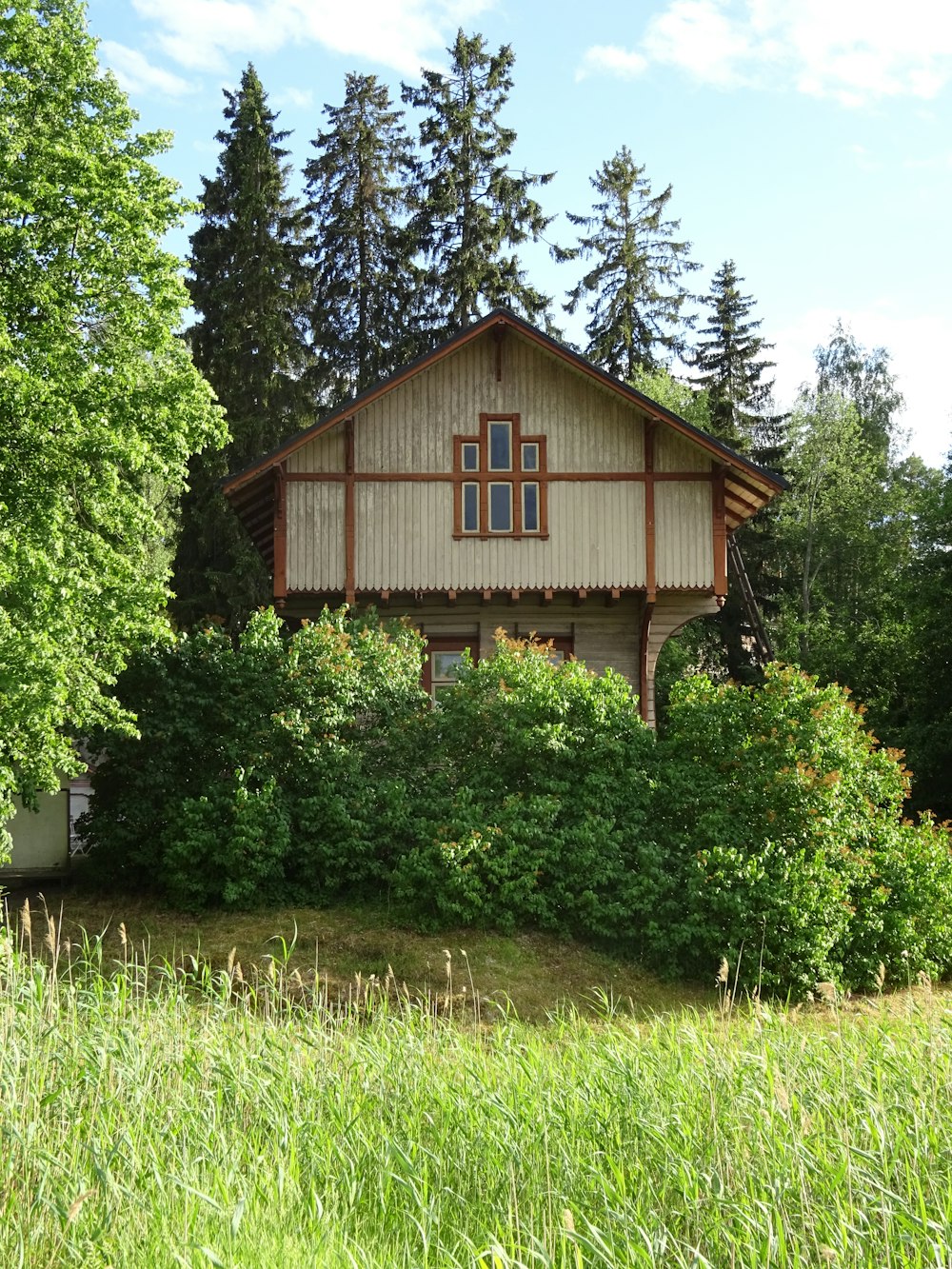 a house in the middle of a field with trees in the background