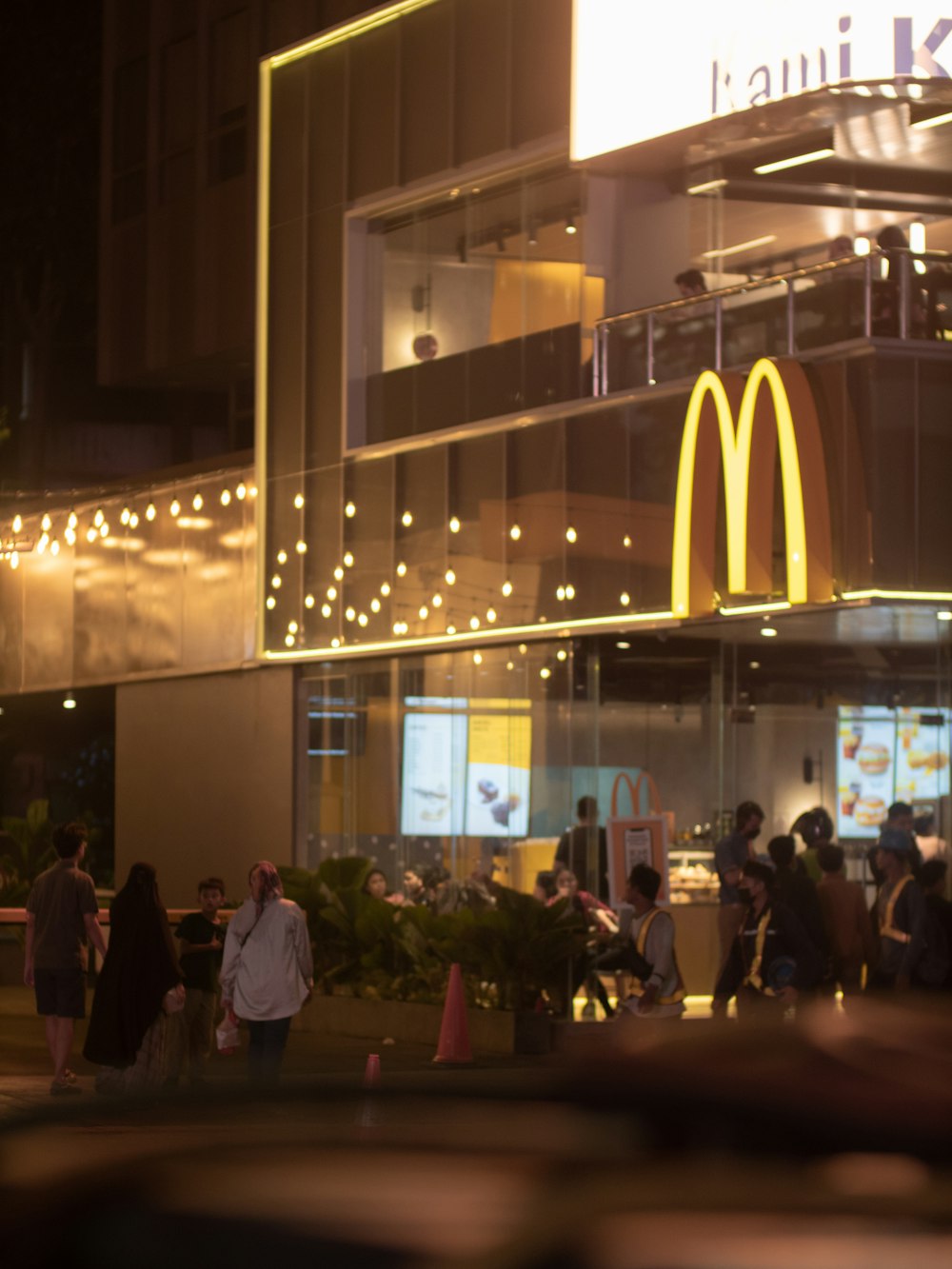 a group of people standing outside of a mcdonalds