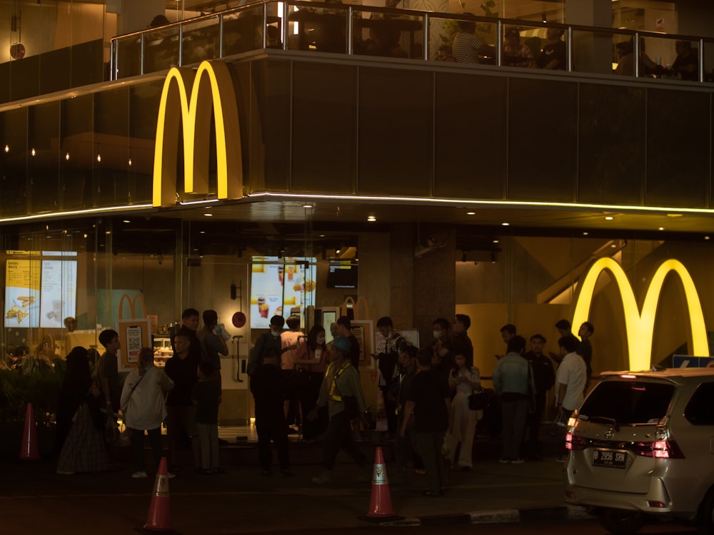 a group of people standing in front of a mcdonalds