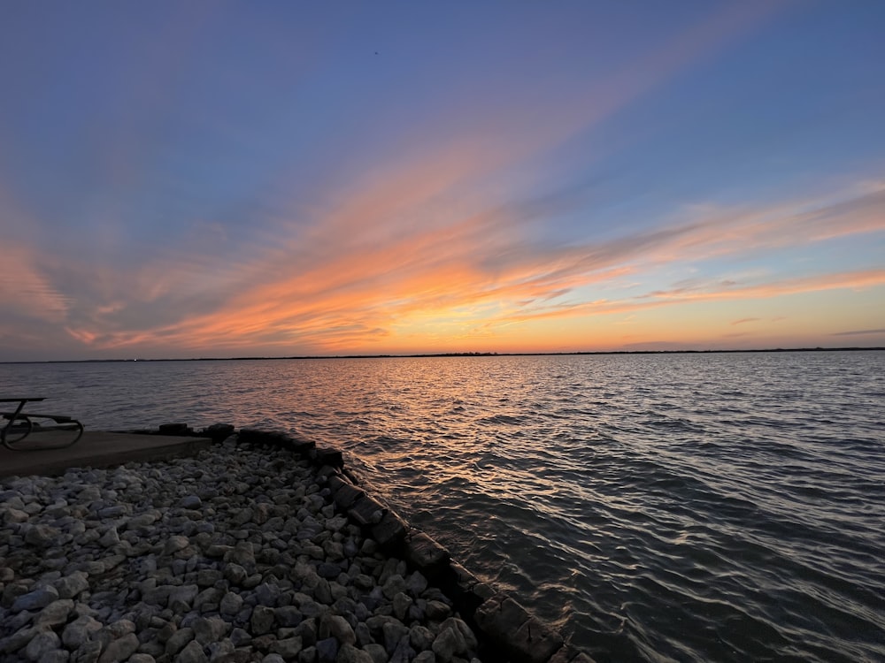 a bench sitting on the edge of a body of water