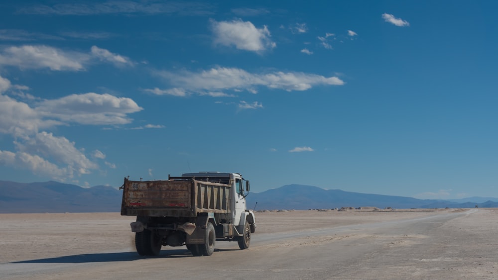 Un camión volquete conduciendo por una carretera desértica