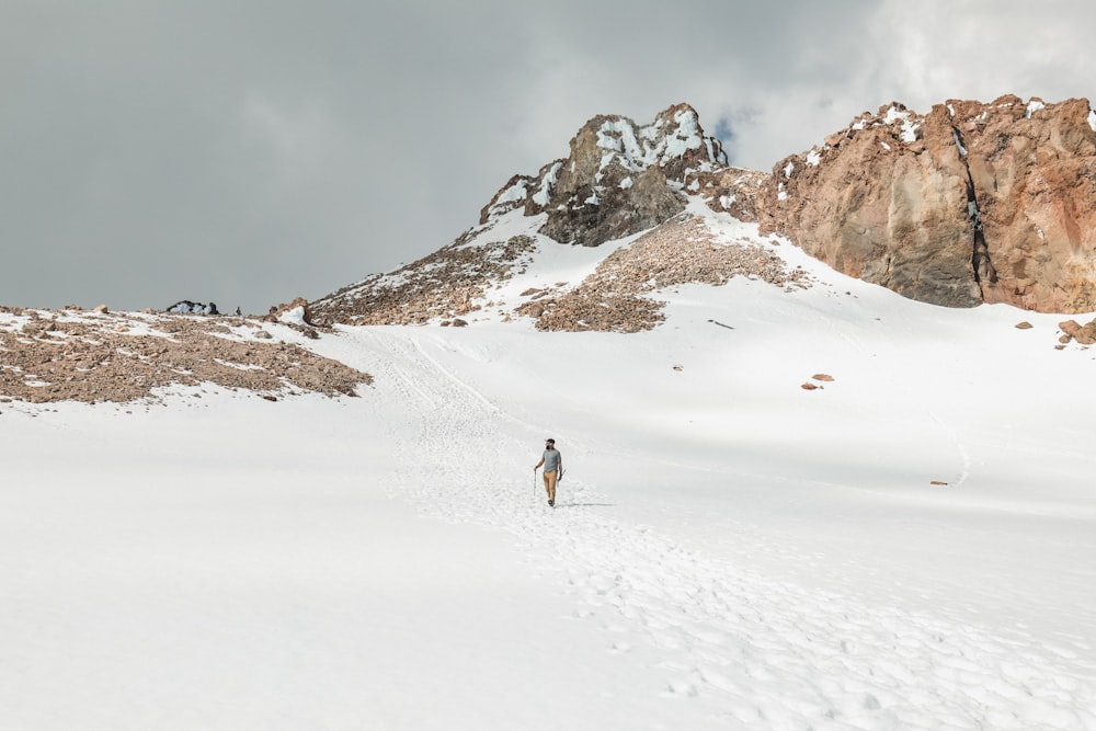a person walking across a snow covered mountain