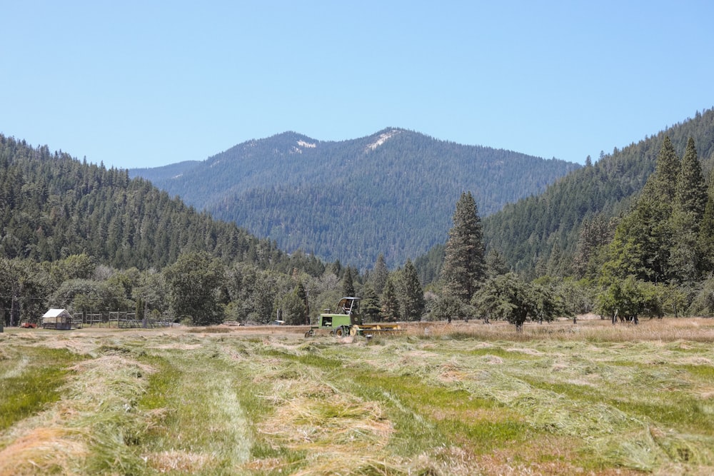 a tractor is parked in a field with mountains in the background