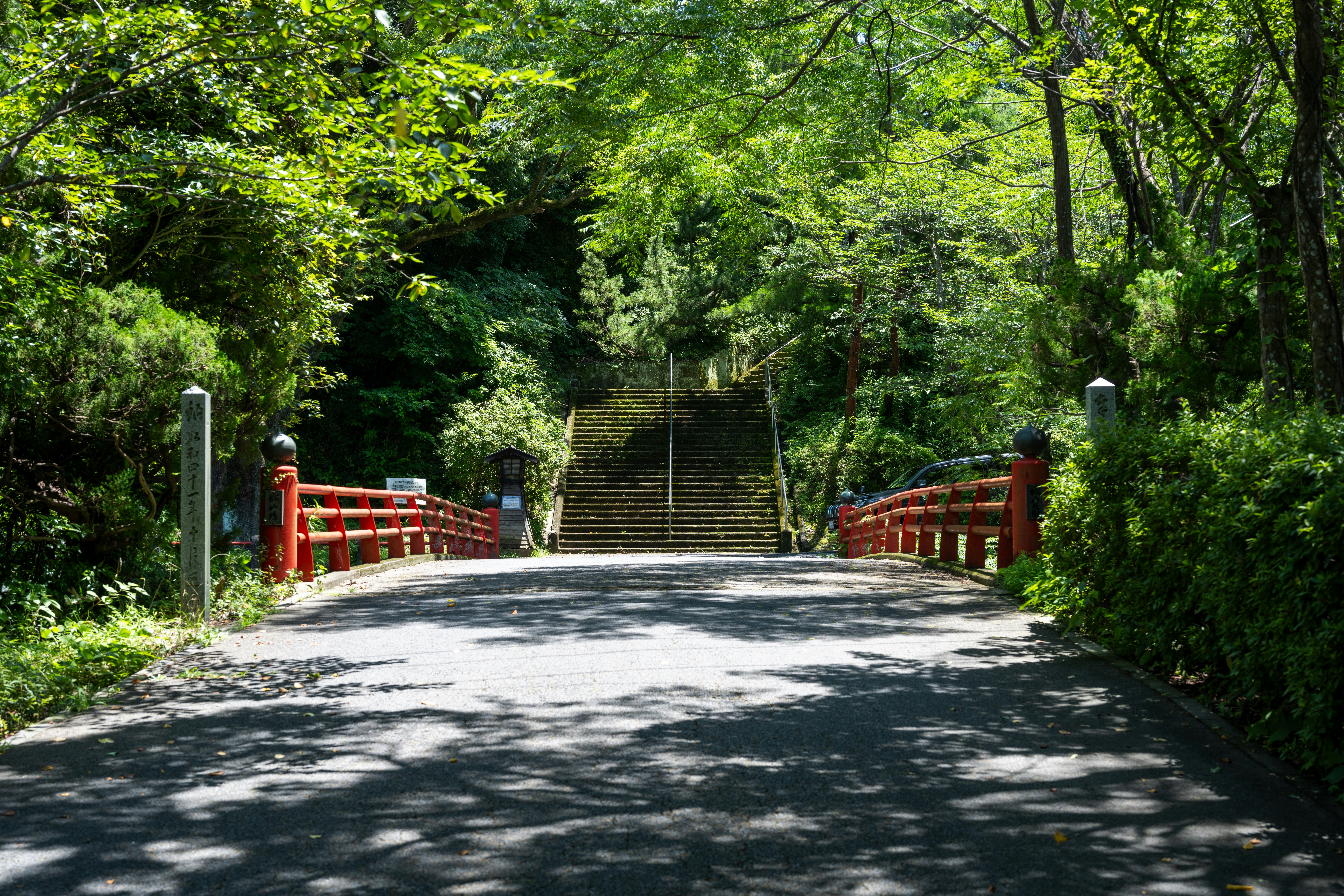 a road with a red fence and a set of stairs