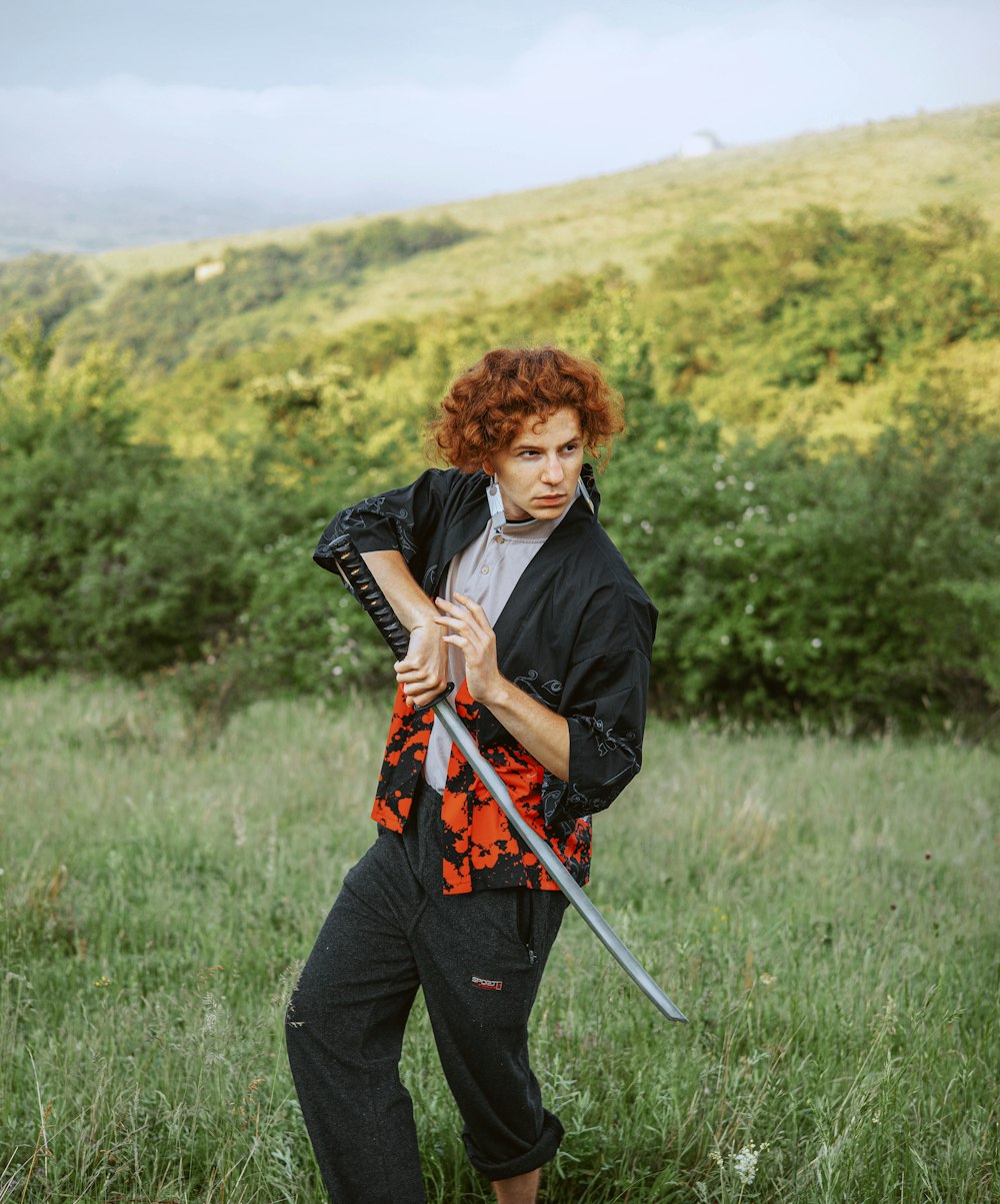 a woman holding a sword in a field