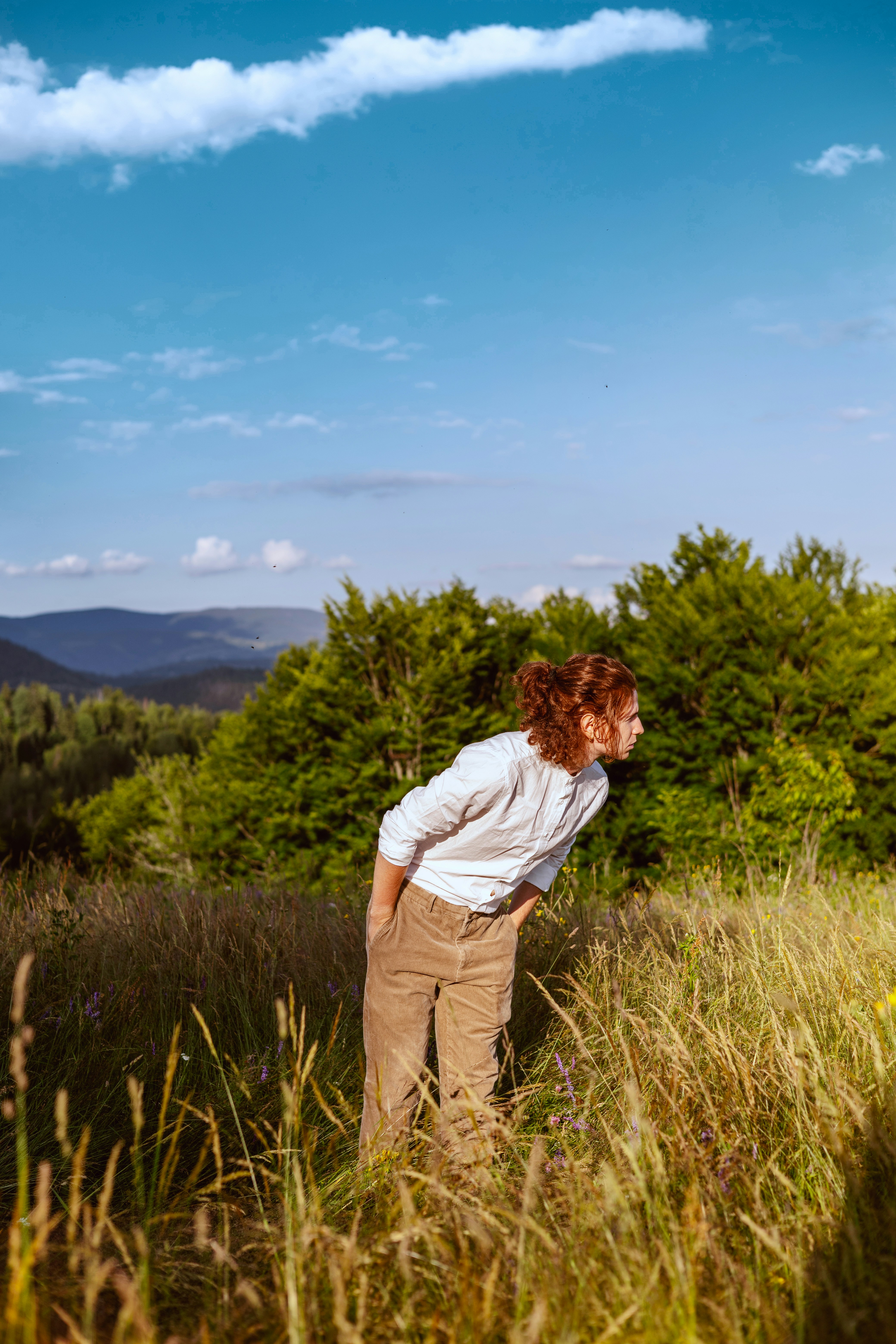 a woman standing in a field of tall grass