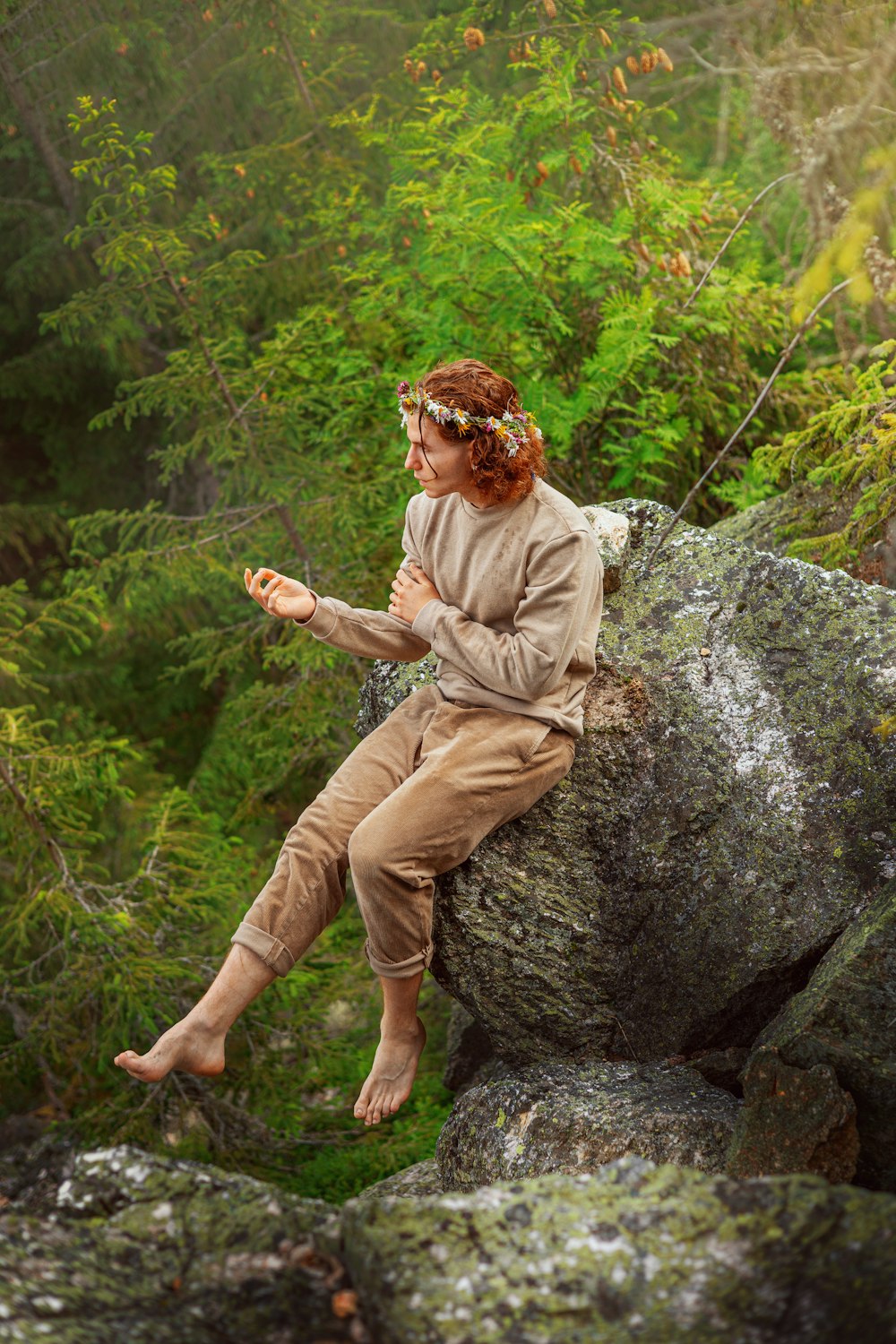 a woman sitting on a rock in the woods