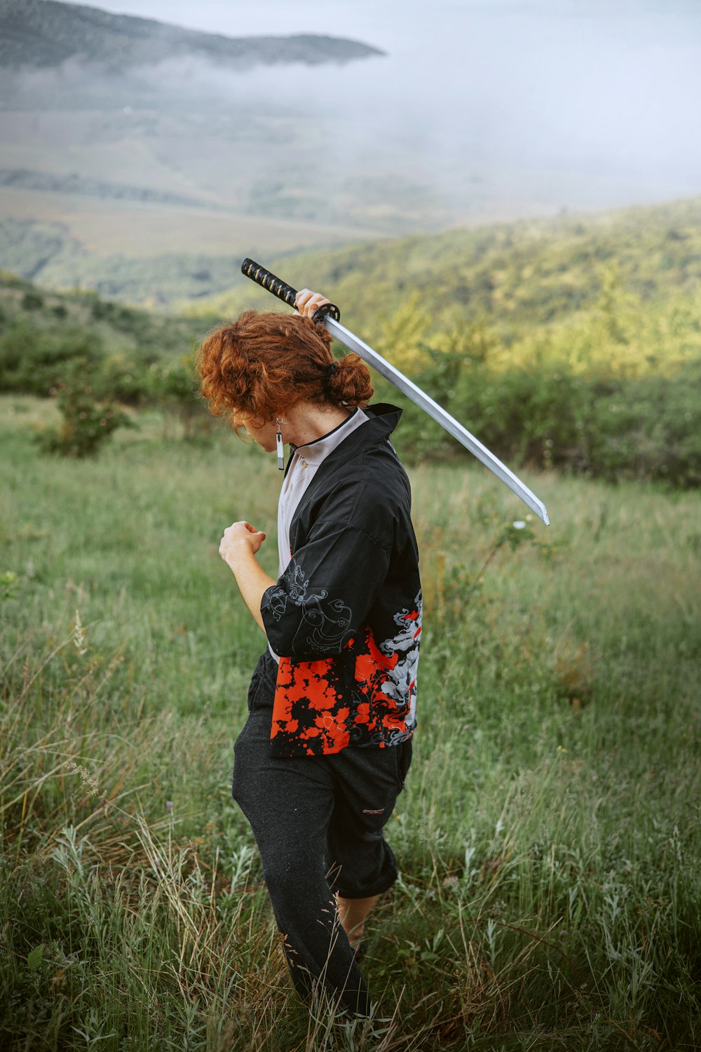 a woman in a field with a sword on her head