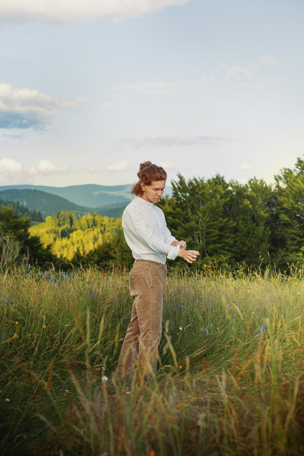 a woman standing in a field of tall grass