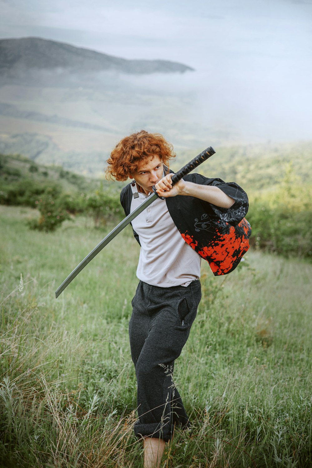 a man with red hair is holding a sword