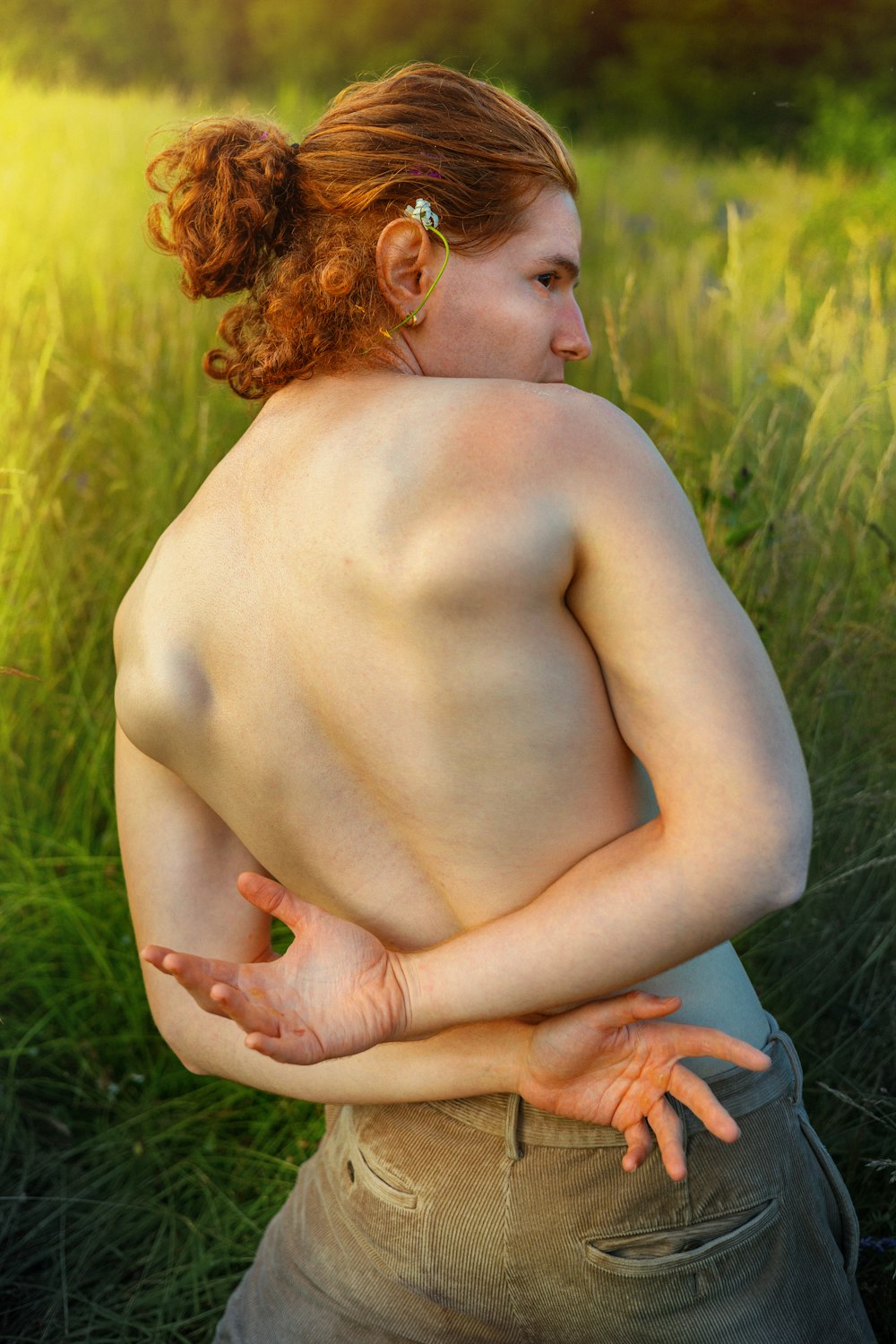 a woman standing in a field with her back to the camera