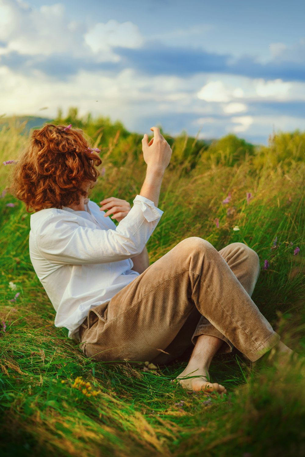 a woman sitting in a field of tall grass