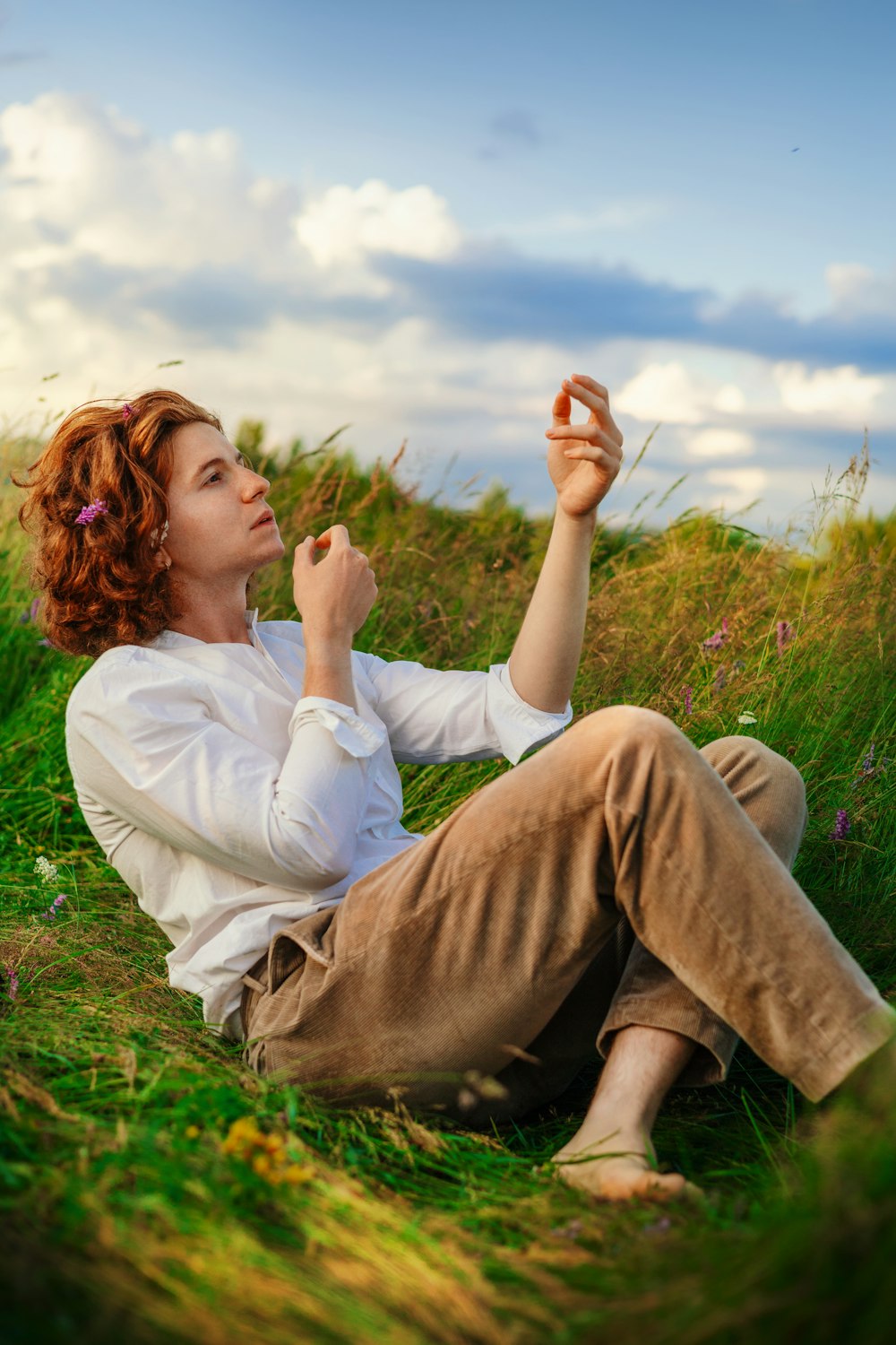 a woman sitting on the ground in a field