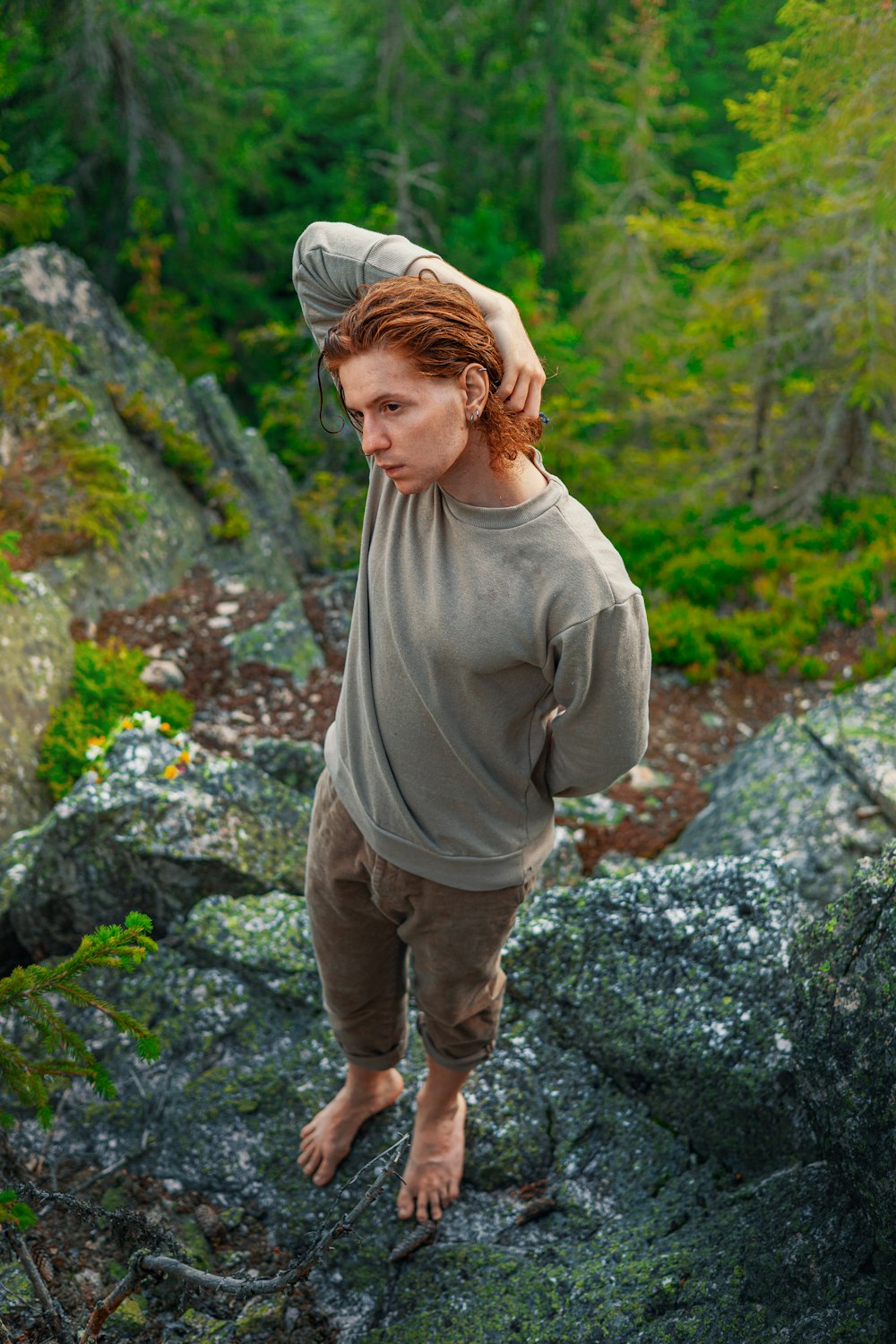 a woman standing on a rock in the woods