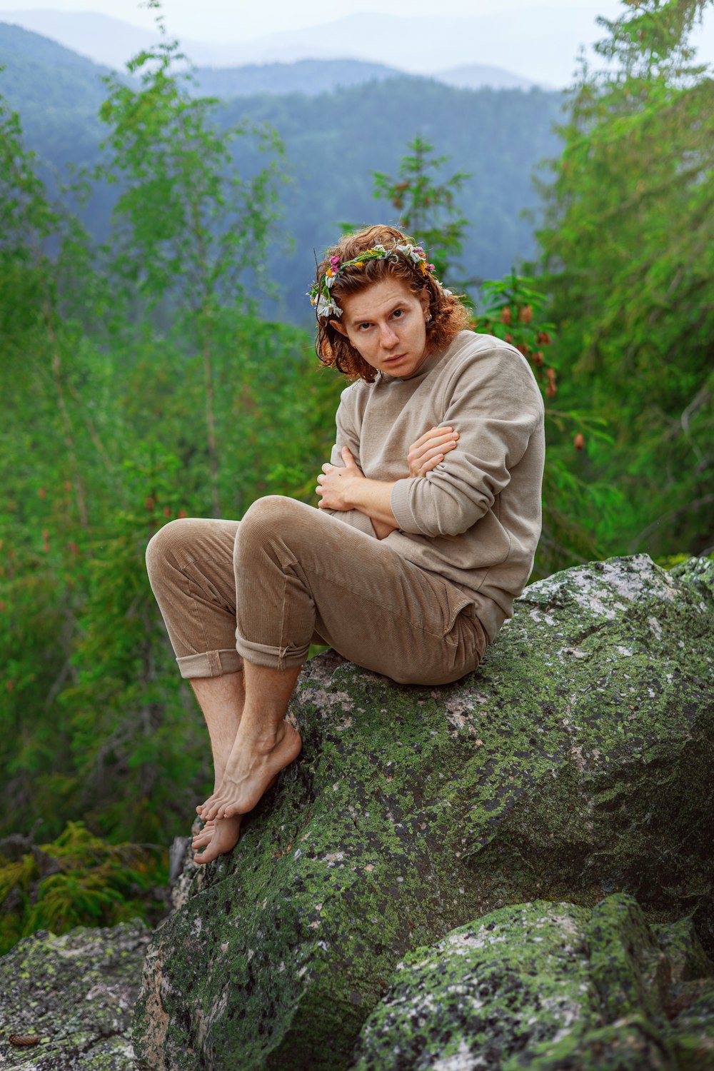 a woman sitting on a rock with her arms crossed