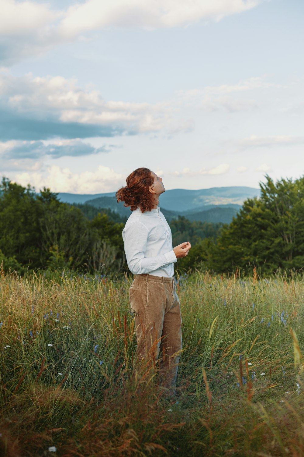 a woman standing in a field of tall grass