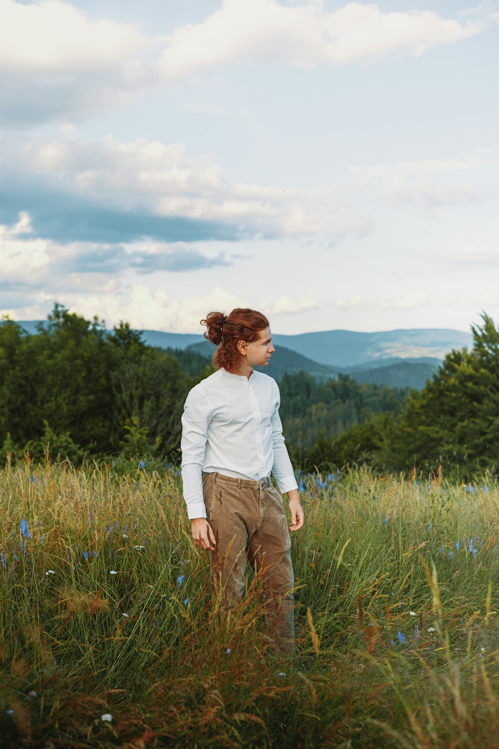 a woman standing in a field of tall grass