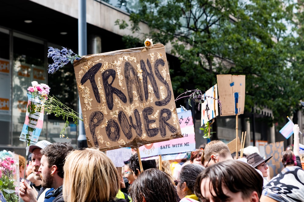 a crowd of people holding signs and flowers