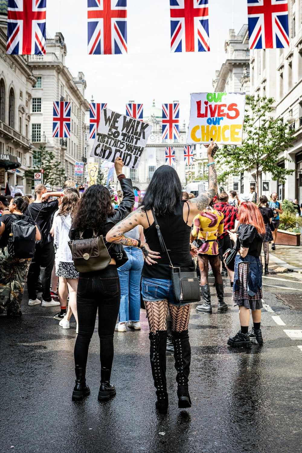 Un gruppo di persone che camminano lungo una strada con bandiere