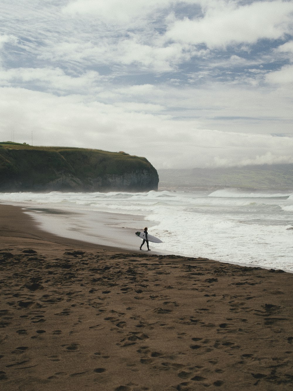 a person walking on a beach near the ocean