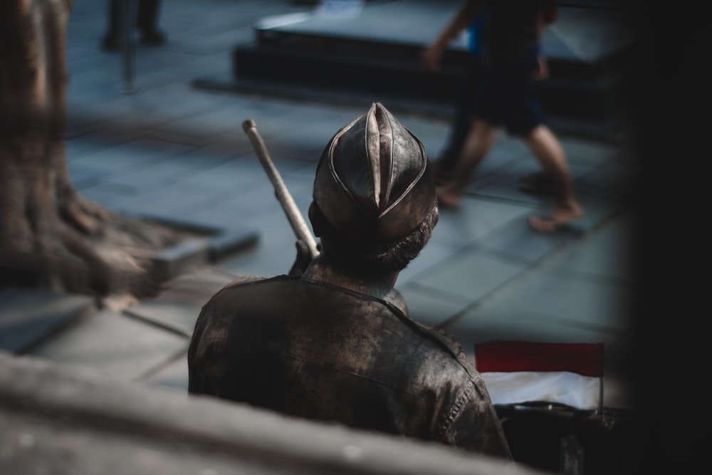 um homem de jaqueta de couro com um pau na mão