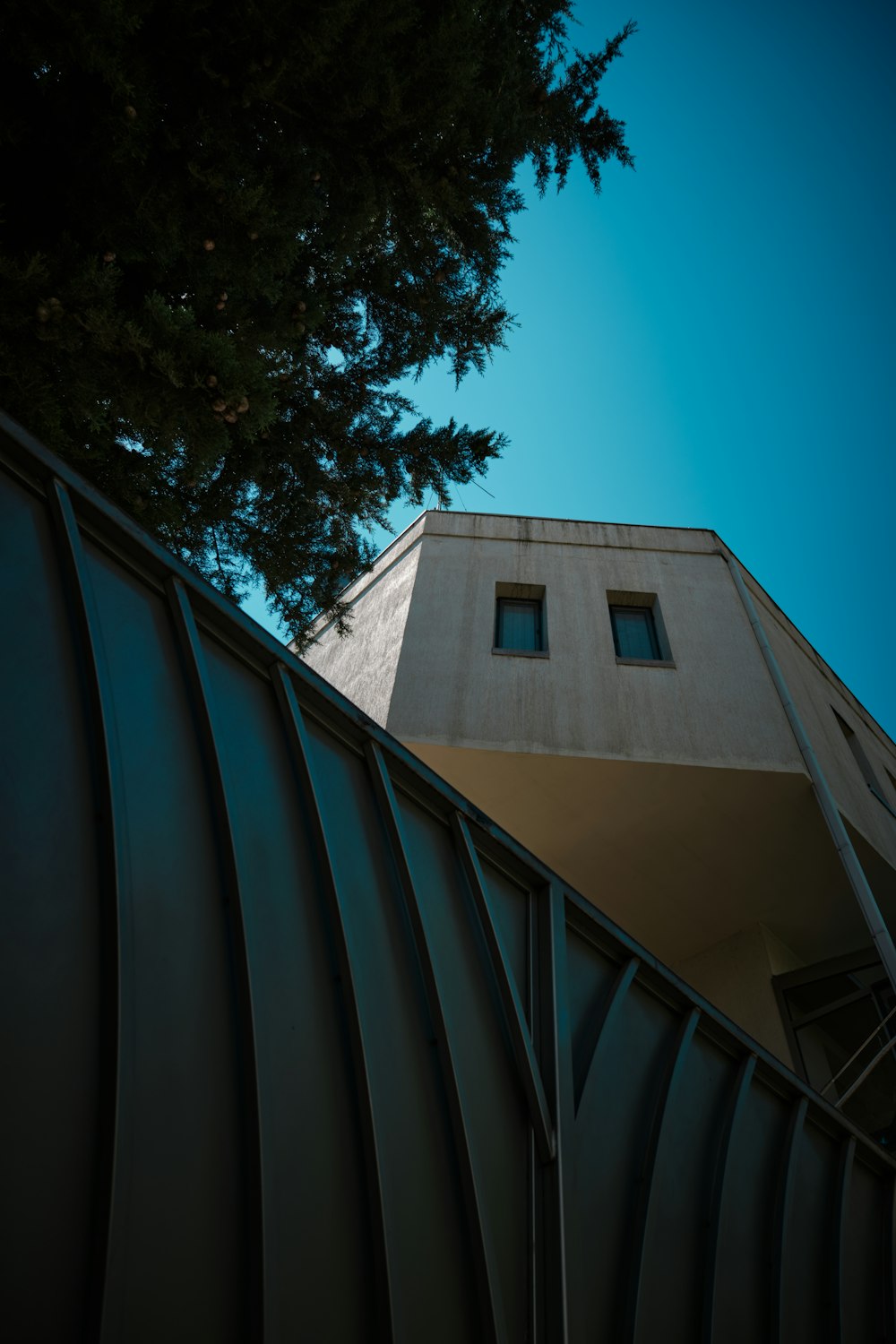 a tall building with two windows next to a tree