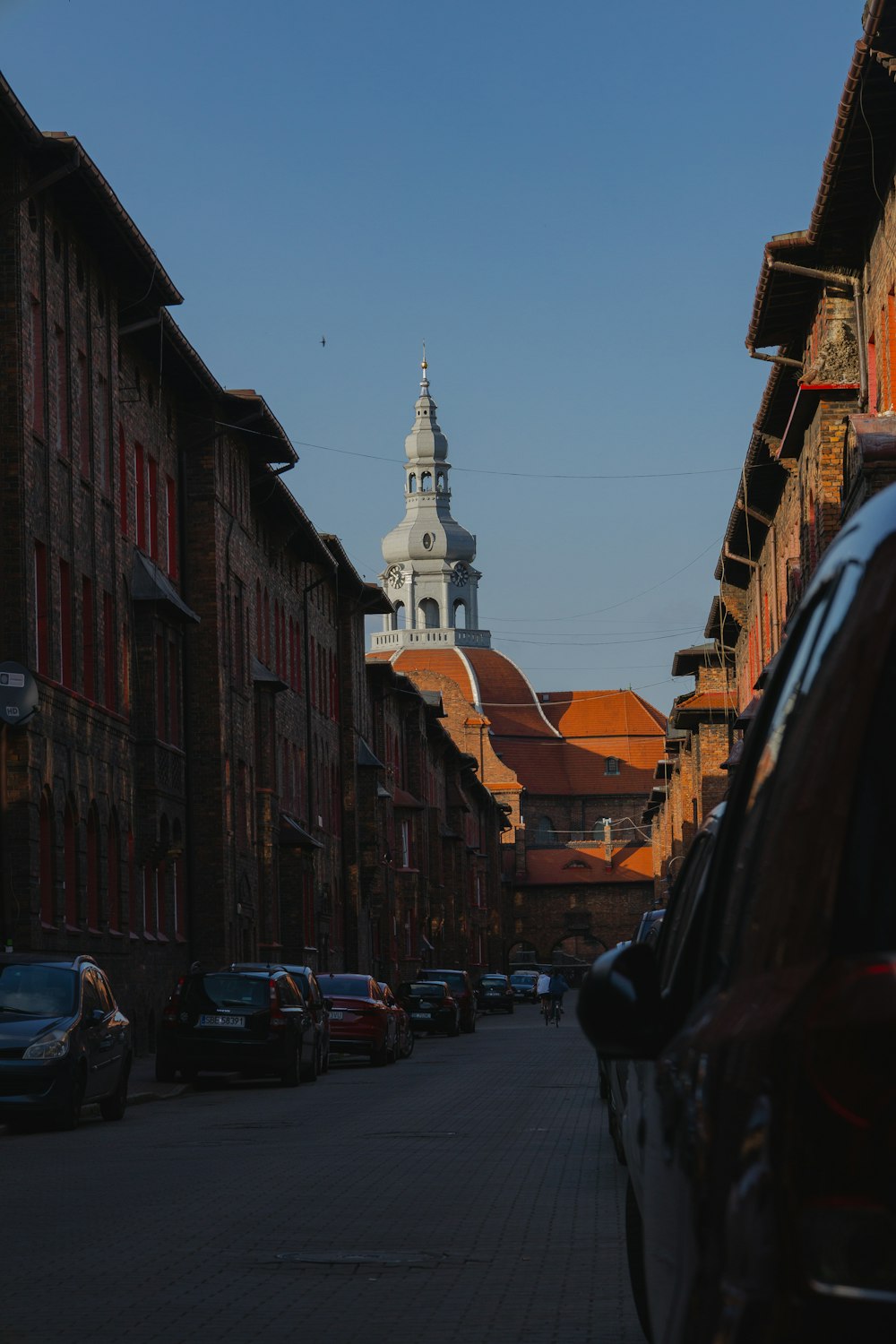 a city street with a church steeple in the background