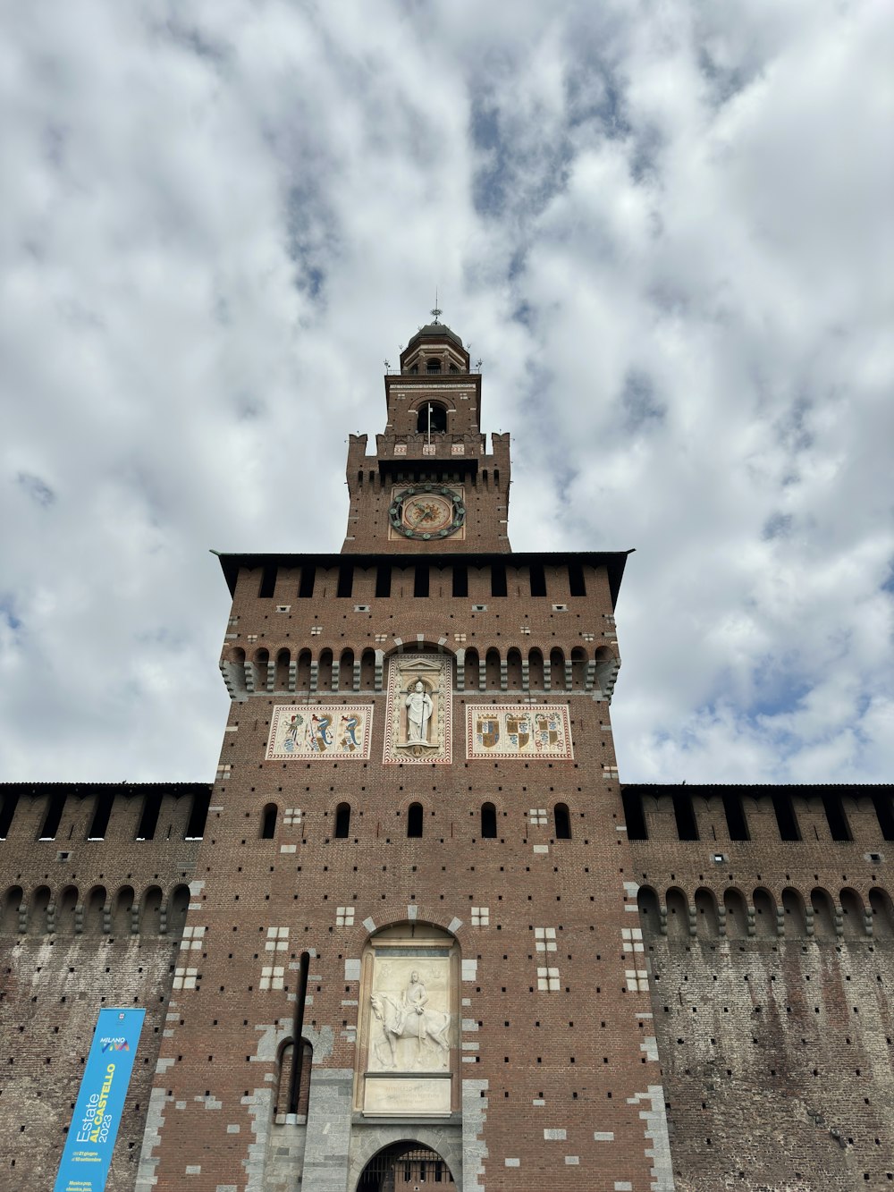 a tall brick building with a clock on it's side