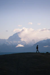 Golden hour shot of a person walking effortlessly with an exoskeleton in the mountains.