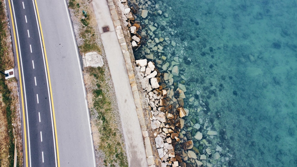 an aerial view of a road next to the ocean